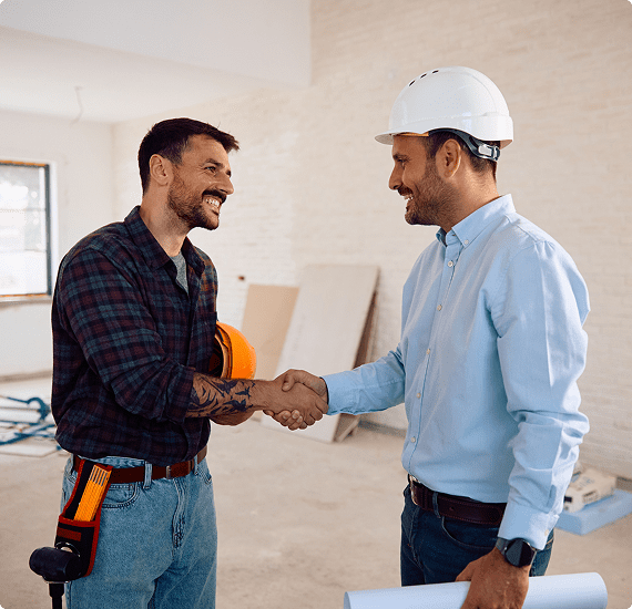 Contractor and client shaking hands at construction site